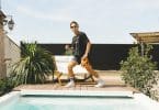 woman in black shirt and yellow shorts standing on swimming pool during daytime