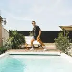 woman in black shirt and yellow shorts standing on swimming pool during daytime