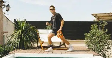 woman in black shirt and yellow shorts standing on swimming pool during daytime