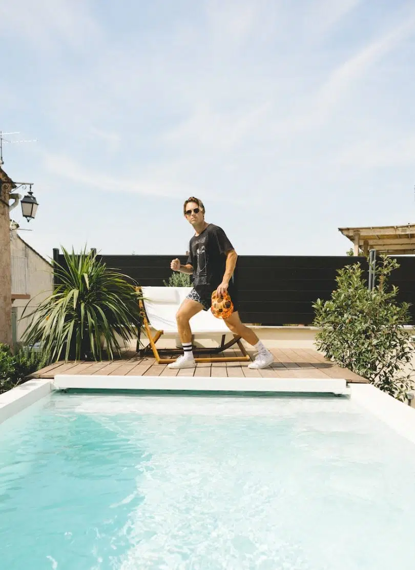 woman in black shirt and yellow shorts standing on swimming pool during daytime